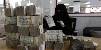 موظفة في البنك المركزي اليمني في صنعاء ترتب العملات الورقية المحلية