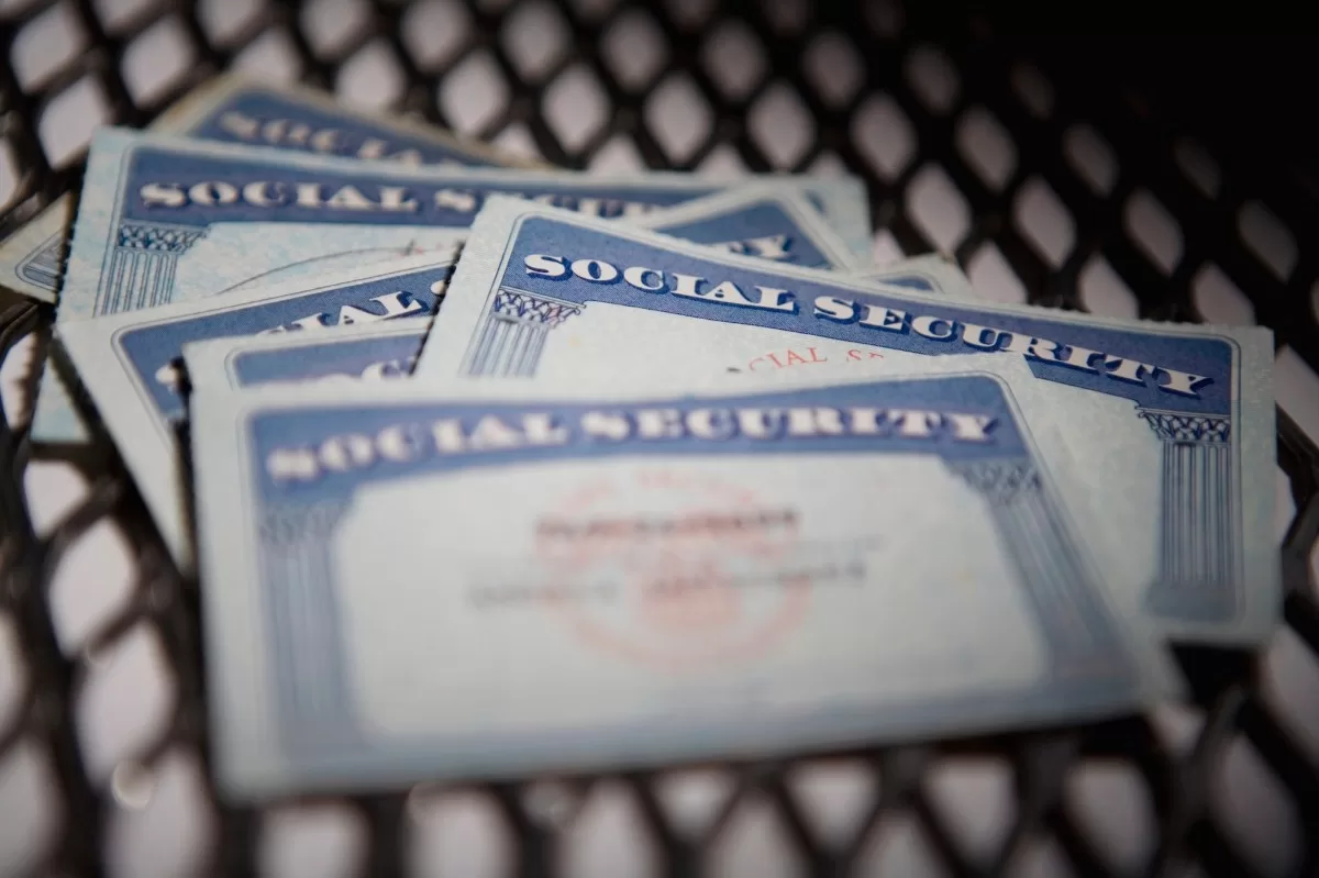 a close up shot of several Social Security cards on a chequered mat.