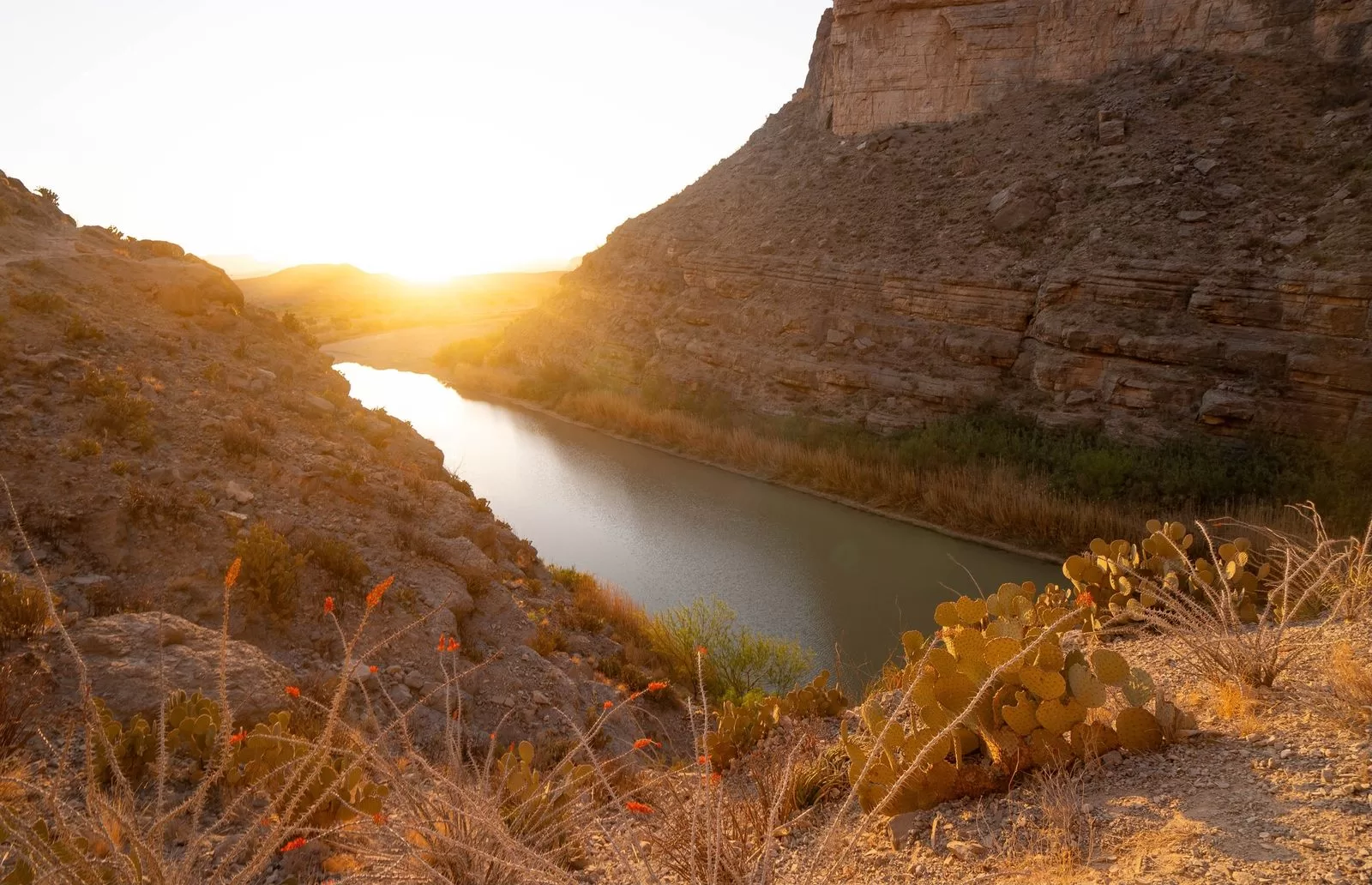 Image may contain Outdoors Nature Scenery Rock Water Mountain Flare Light Landscape Sky and Sunlight