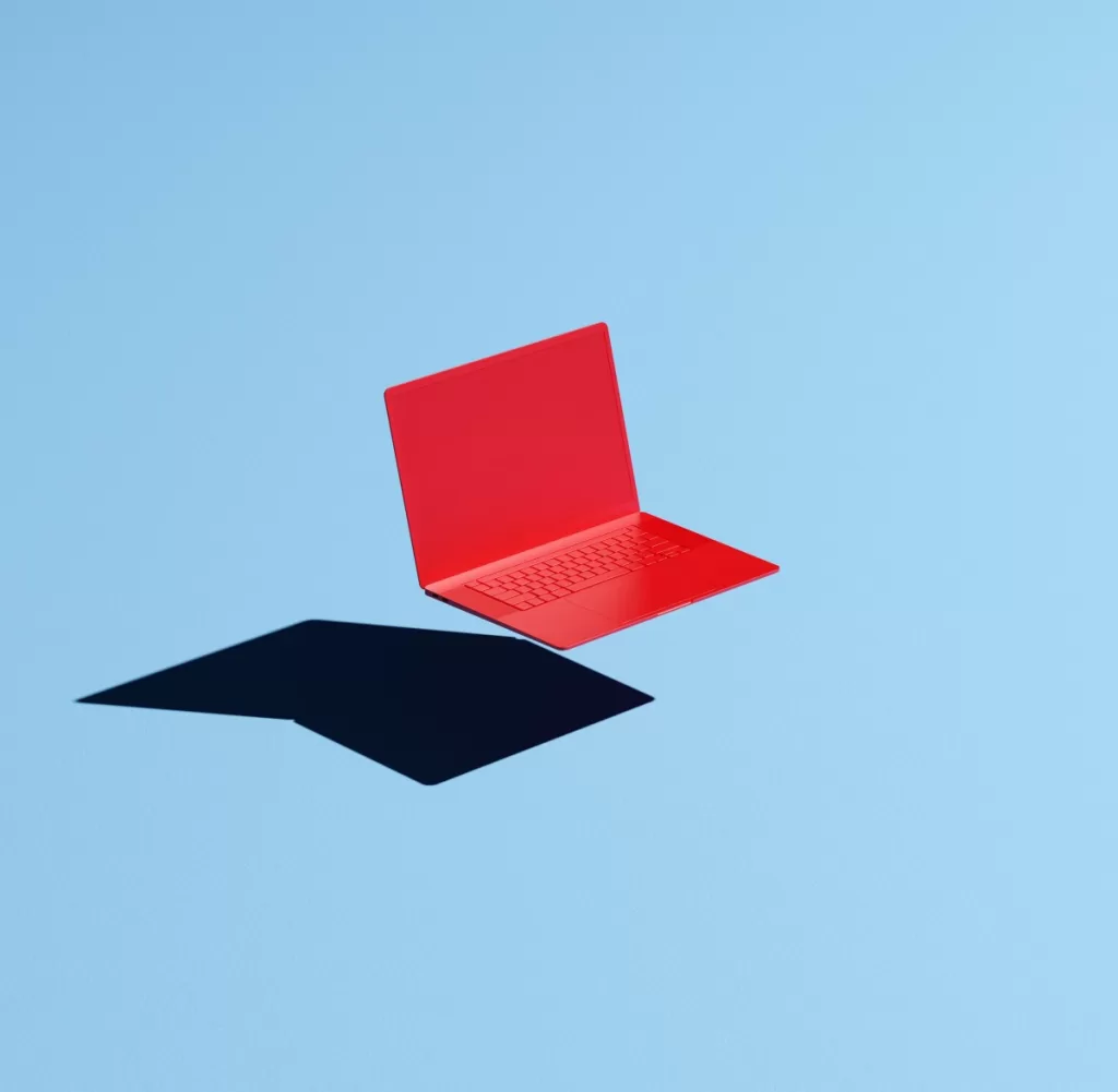 Conceptual image of a red laptop floating mid-air on a blue background with a hard shadow