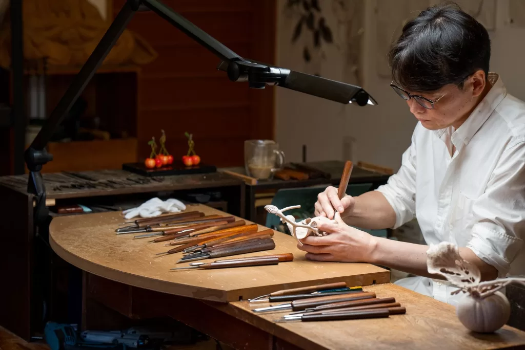 Image may contain Inoran Person Accessories Glasses Cup Woodworking Desk Furniture Table and Pen