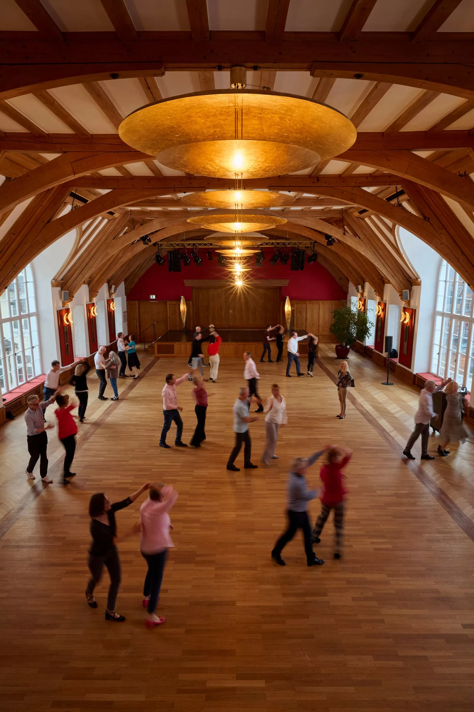 Image may contain Floor Flooring People Person Lighting Wood Ballroom Indoors Room Walking Clothing and Footwear