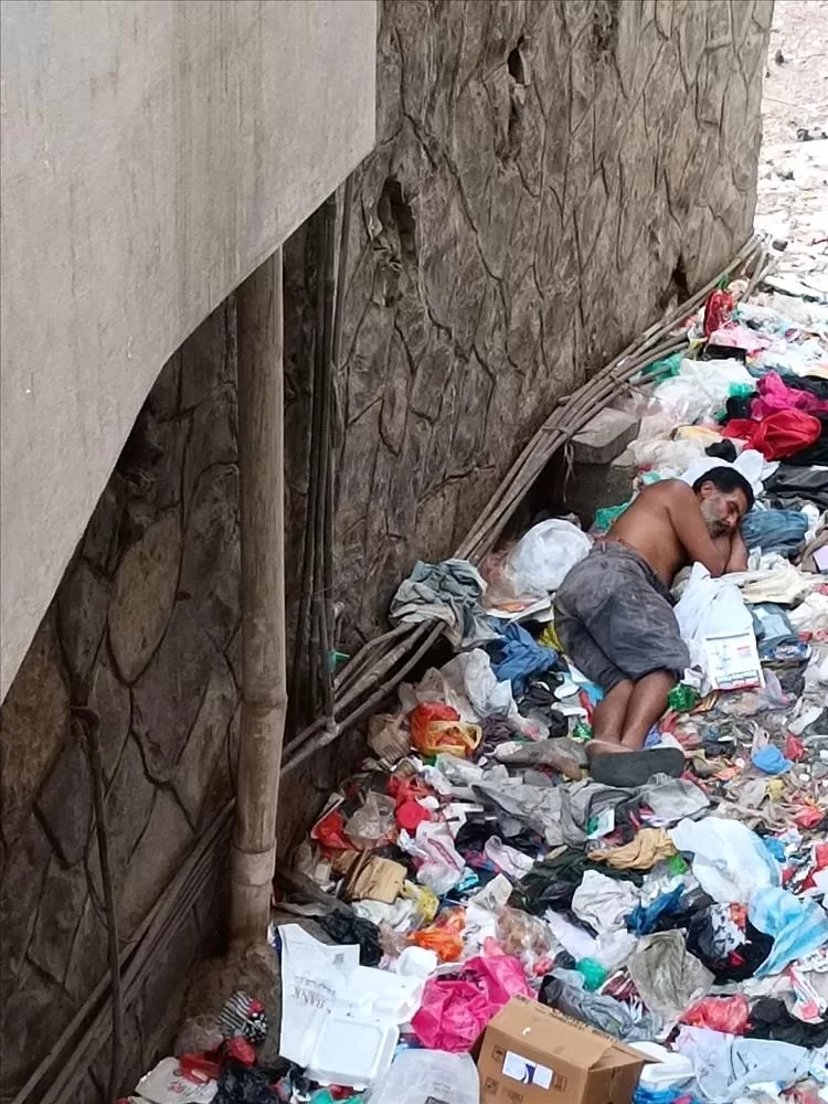 شابٌ ينام على أكوام القمامة خلف عمارات المعلا.. صرخة إنسانية بوجه الإهمال!