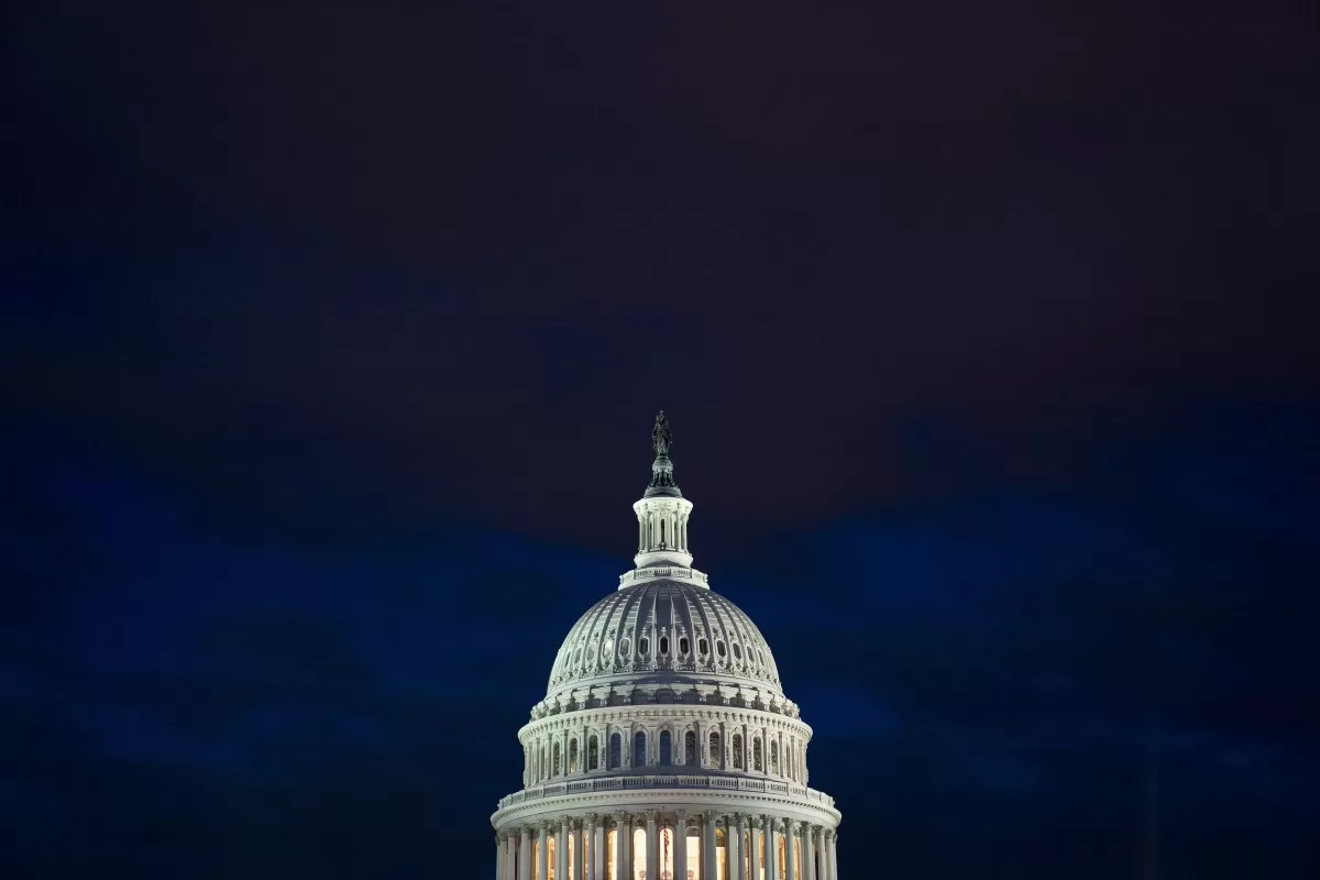 The U.S. Capitol building illuminated against a dark sky in Washington, D.C.,