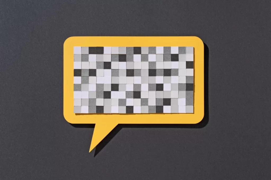 Paper Craft Pixel Mosaic Covering a Yellow Speech Bubble on Gray Background Front View, Censorship Concept.