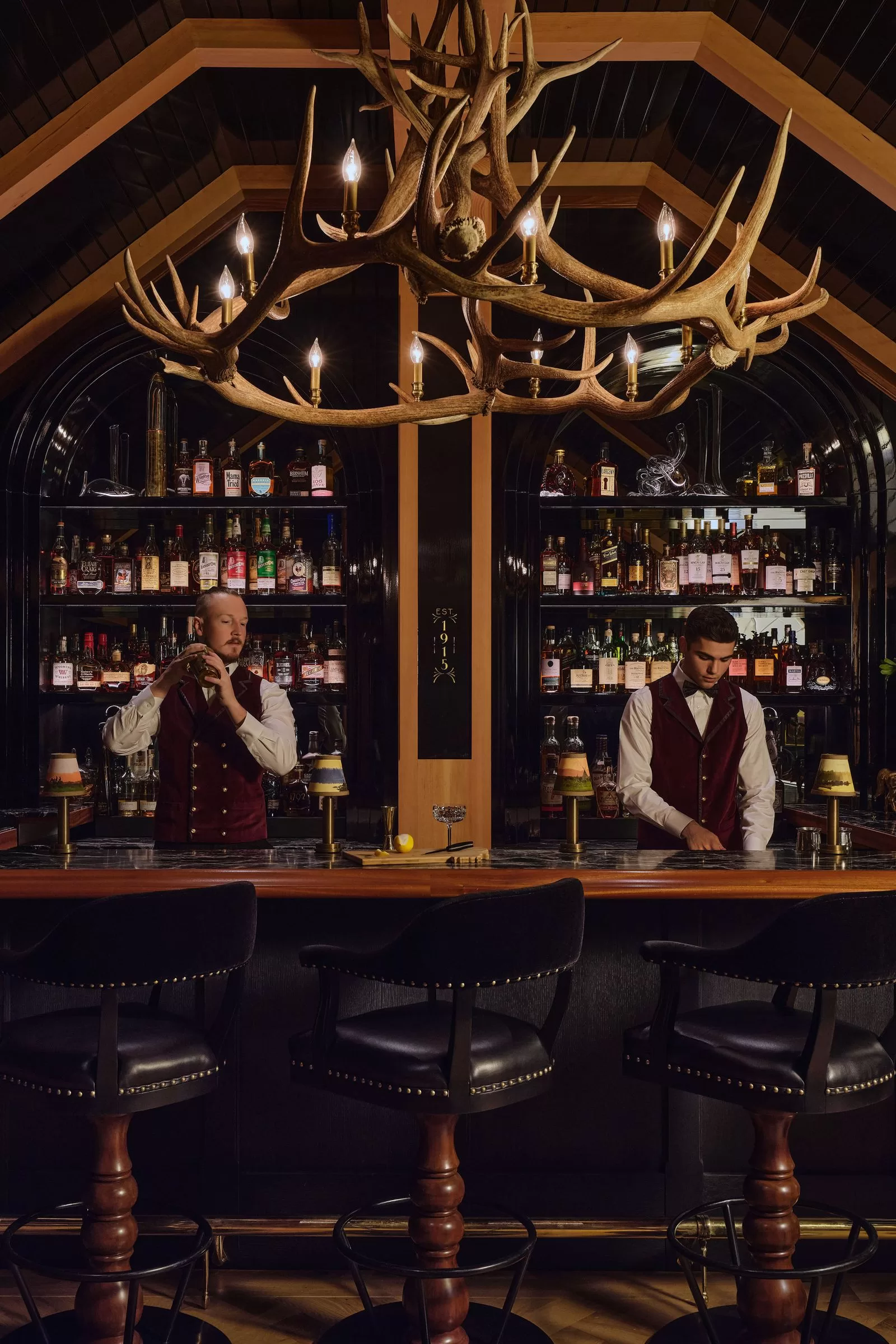 قد تحتوي الصورة على جون ستيفنز سيرجيو ماير كرسي أثاث شخص بالغ مصباح بار مكتب حضري وطاولة