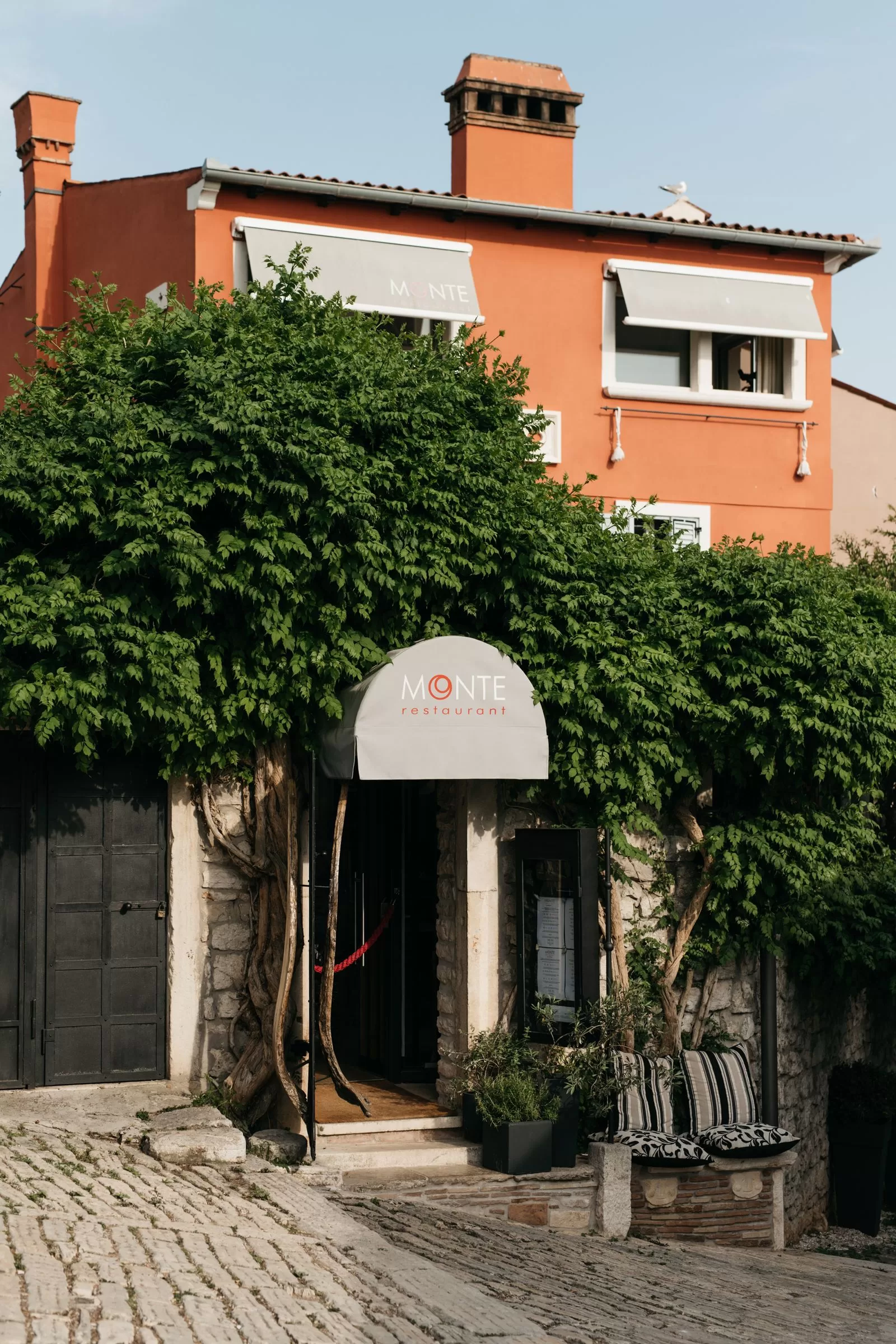 الصورة قد تحتوي على مدينة حضرية طريق معمارية مبنى في الهواء الطلق ملجأ مقعد أثاث منزل مسكن وفيللا