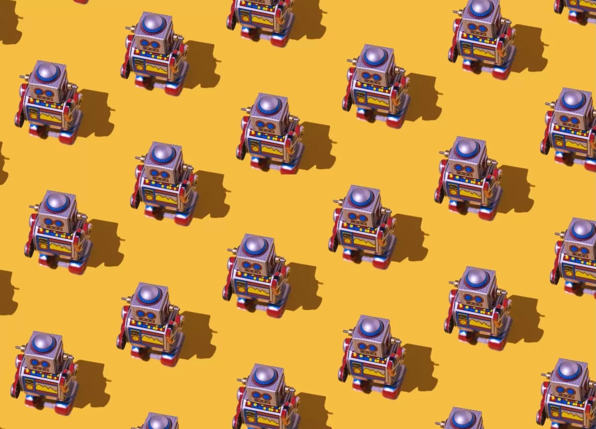 Pattern of retro tin toy robots with clocks and displays painted on yellow background.