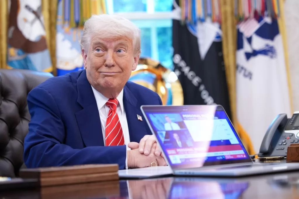 President Donald Trump,shows a news video from a laptop in the Oval Office of the White House on May 30, 2025 in Washington, DC.