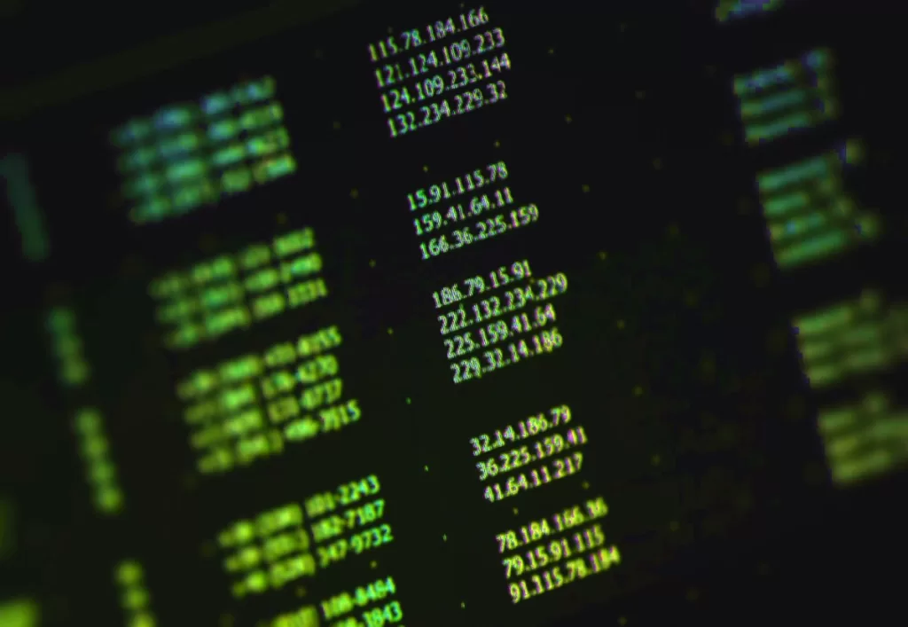a stock photo of a list of random IP addresses in green text on a computer monitor at an angle