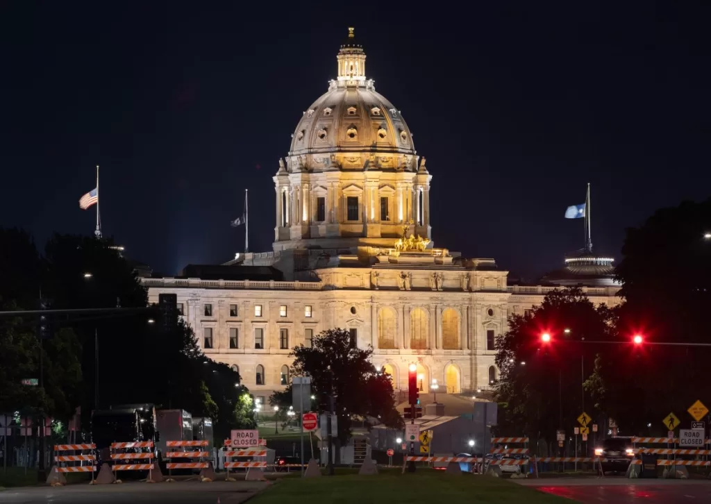 A scenic view of the majestic Minnesota State Capitol building in St. Paul, dramatically illuminated against the night sky