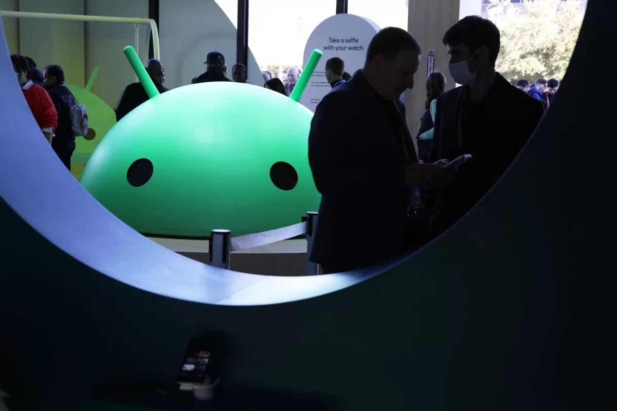 Attendees visit the Google booth where a model of the Android logo is on display at CES 2023 at the Las Vegas Convention Center.