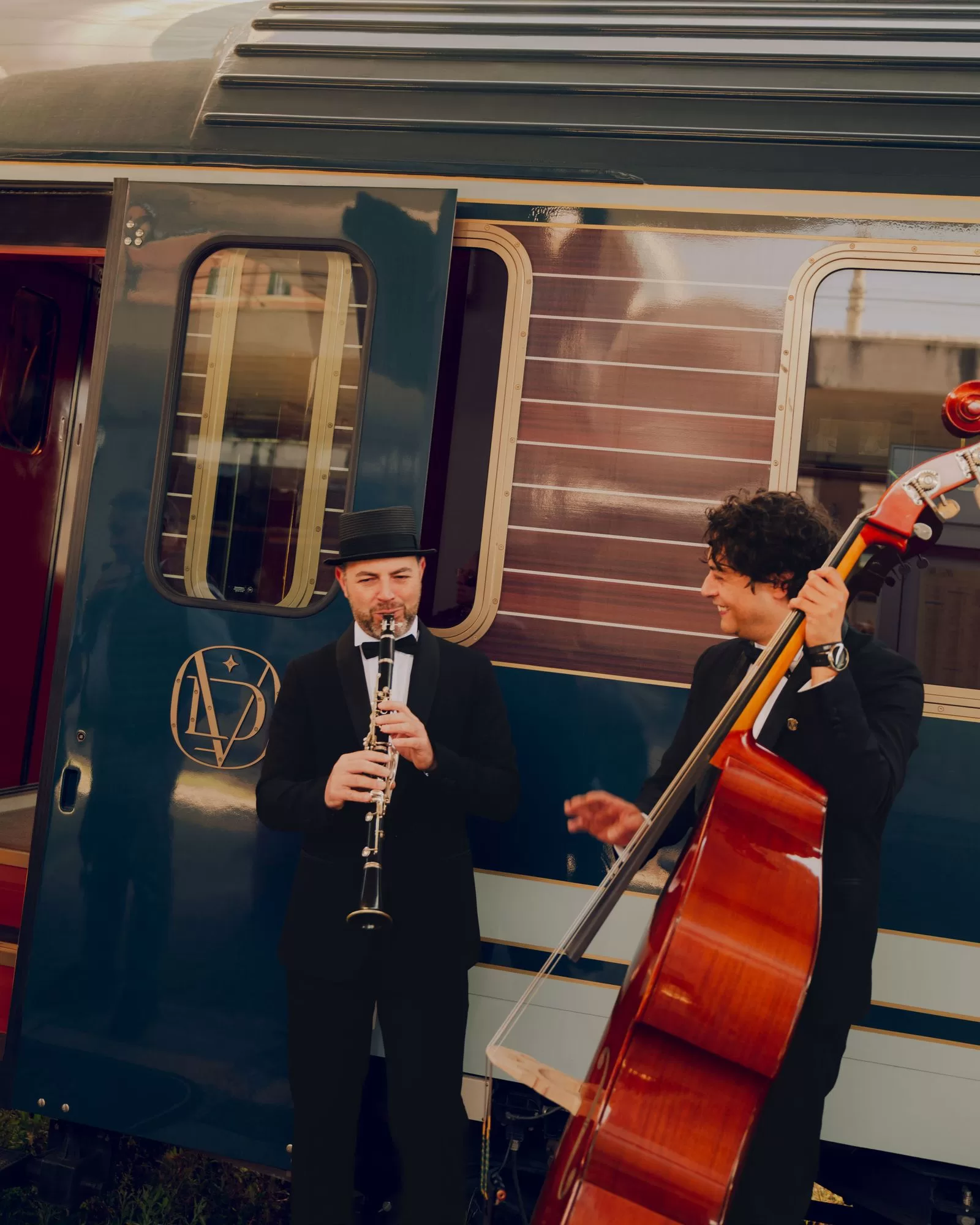 قد تحتوي الصورة على شخص بالغ وملابس وقبعة وساعة يد وآلة موسيقية وقطار وسيلة نقل