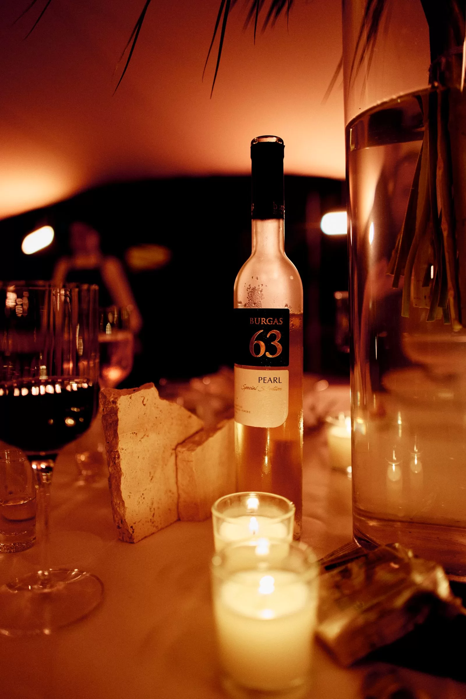 Image may contain Alcohol Beverage Bottle Liquor Wine Wine Bottle Cup Glass Person Bread Food Beer and Candle