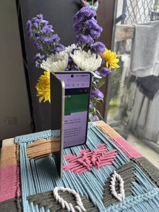 صورة تظهر Honor Magic V5 نصف مفتوح مع فتح موقع TechCrunch.