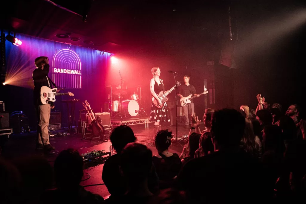 Image may contain Concert Crowd Person Guitar Musical Instrument Lighting Stage Clothing Footwear Shoe and Urban