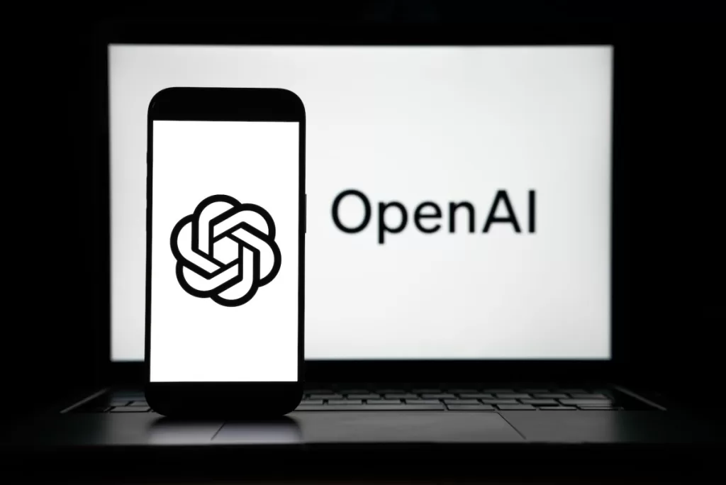 the logos of Open AI displayed on both computer and smart phone screen
