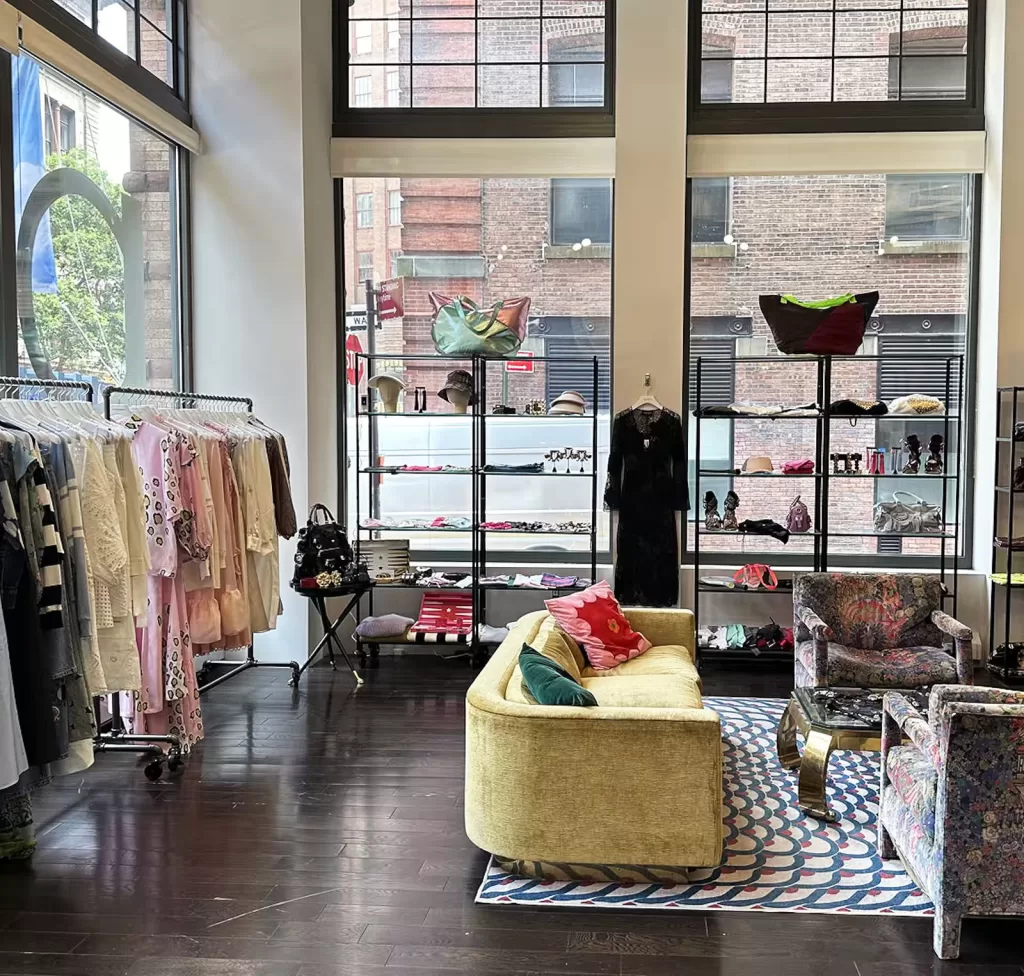 Interior of a fashion store with racks of clothing and colorful couches
