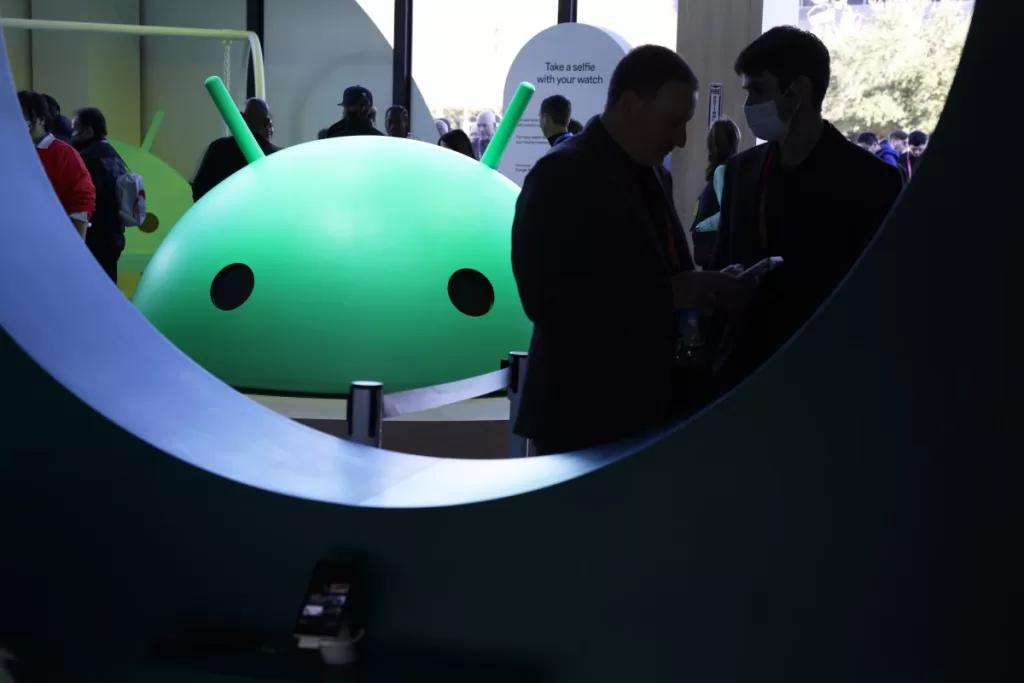 Attendees visit the Google booth where a model of the Android logo is on display at CES 2023 at the Las Vegas Convention Center.