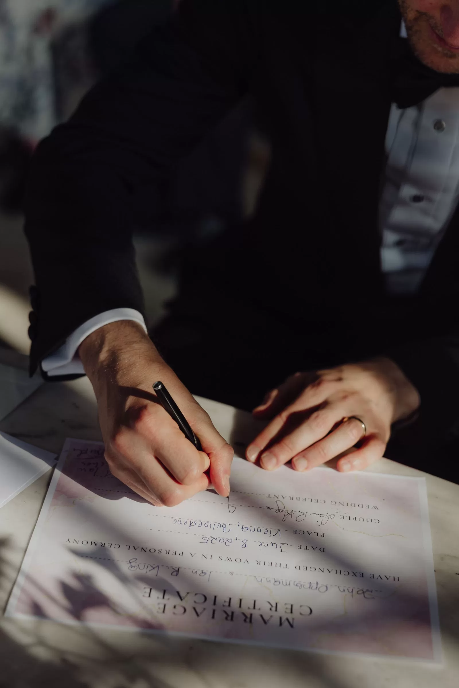 Closeup of a person signing a marriage certificate