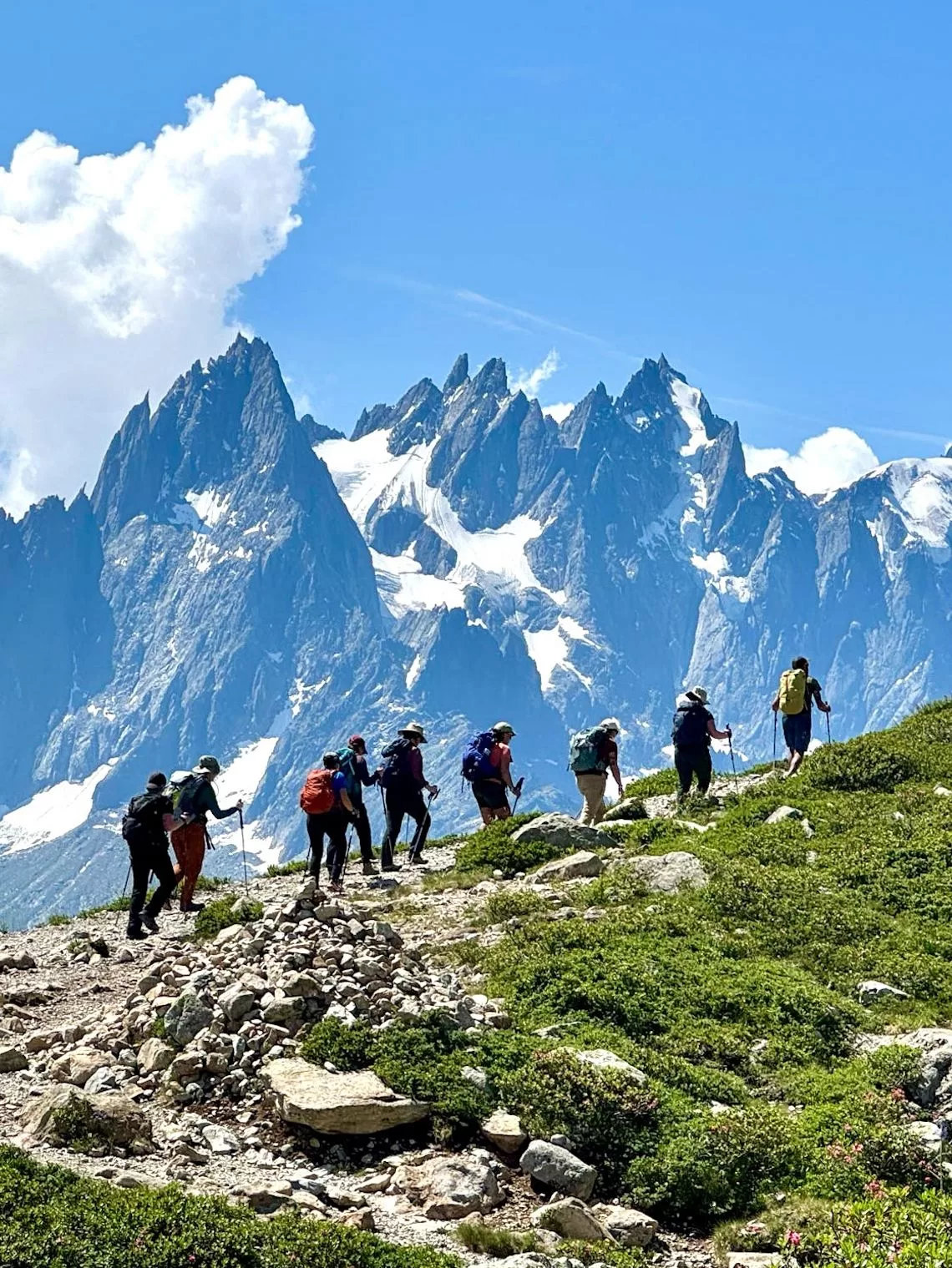 مجموعة من الأشخاص في رحلة تسلق جبل مكسو بالثلوج في يوم مشمس
