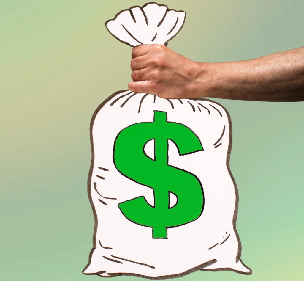 Man's hand holding an illustrated money bag with US dollar sign