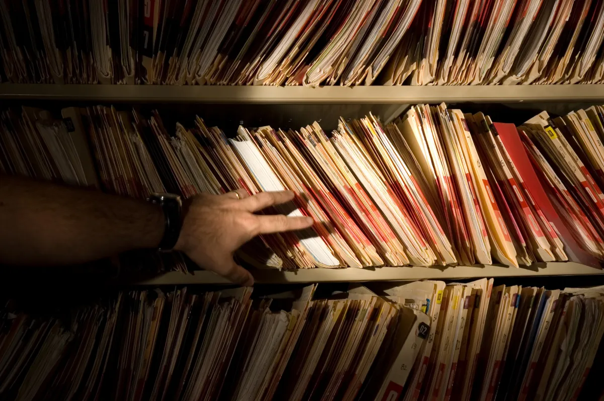 tons of medical records on a shelf in a darkened room