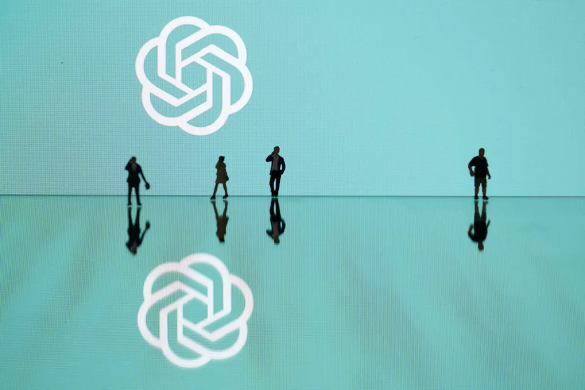 This photograph taken in Mulhouse, eastern France on October 19, 2023, shows figurines next to the ChatGPT logo. (Photo by SEBASTIEN BOZON/AFP via Getty Images)