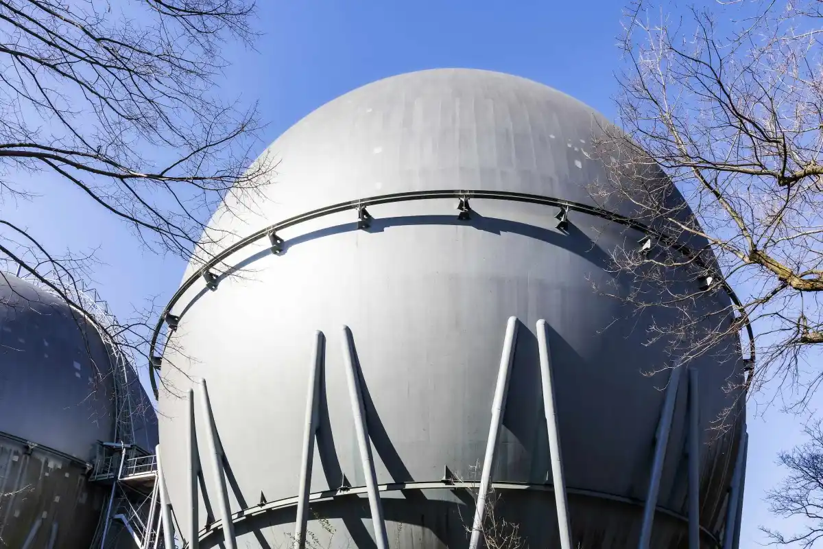 Industrial hydrogen storage tank stands against a blue sky.