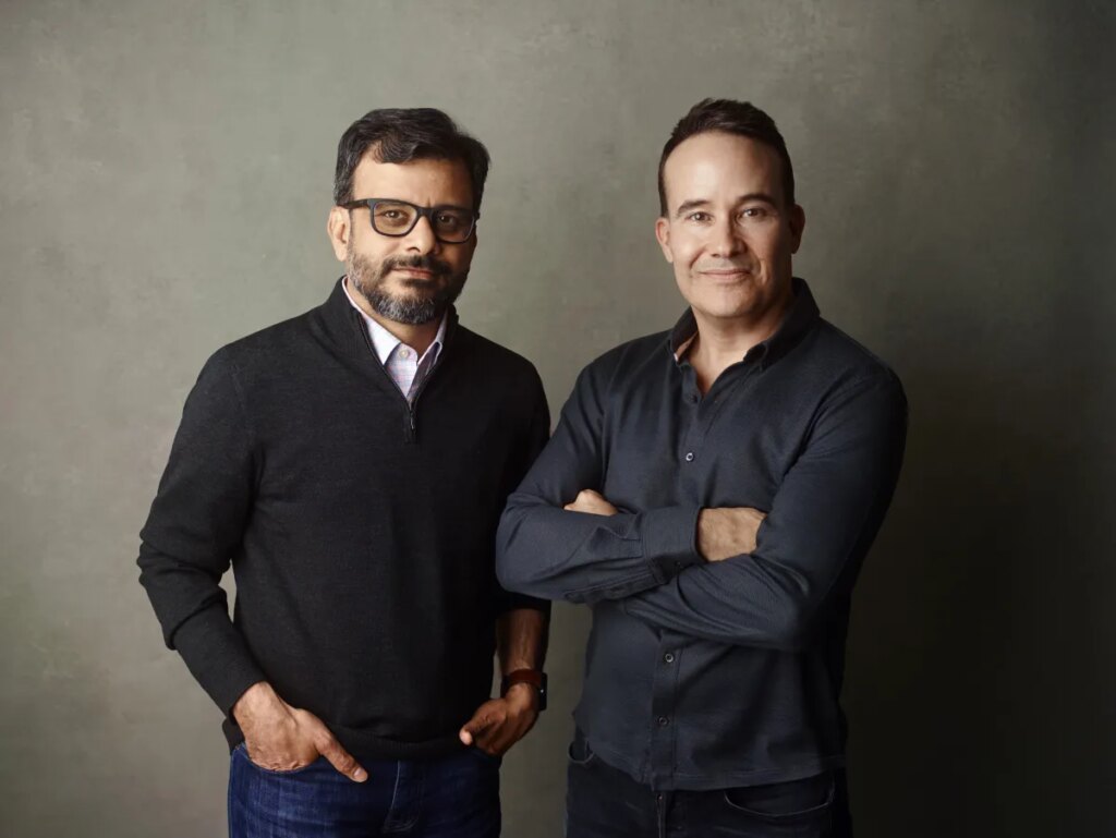 a picture showing the co-founders of Kana, Tom Chavez and Vivek Vaidya, leaning against a grey background