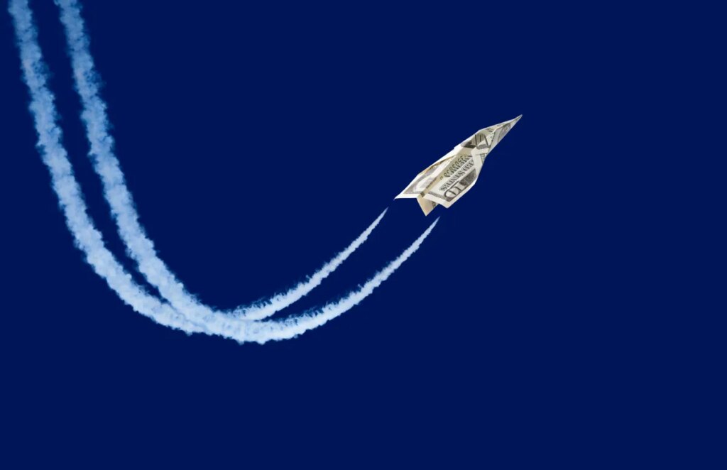 Dollar shaped paper airplane flying up